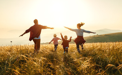 Happy family: mother, father, children son and daughter on sunset.
