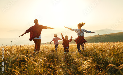 Happy family: mother, father, children son and daughter on sunset.