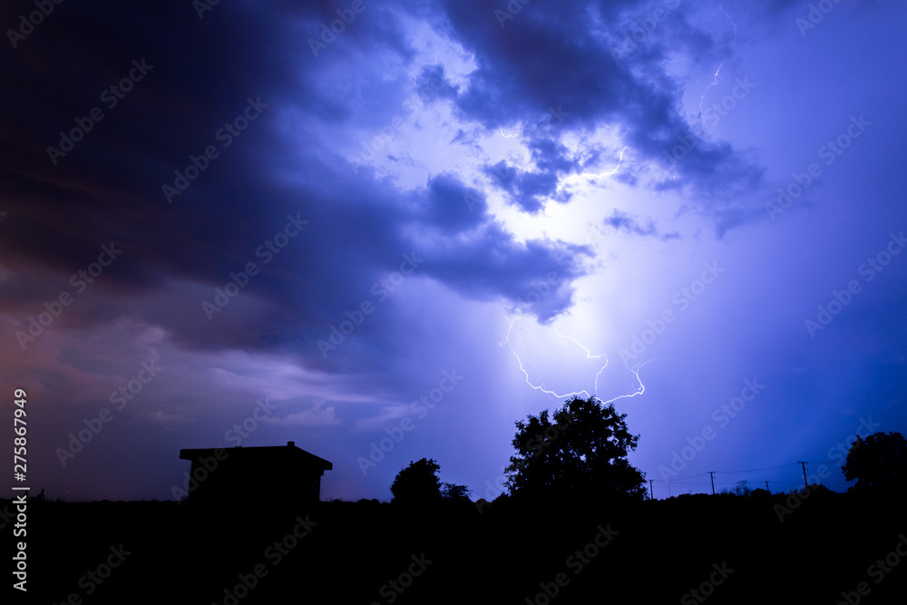 Lightning flashes over the night sky during thunderstorm.