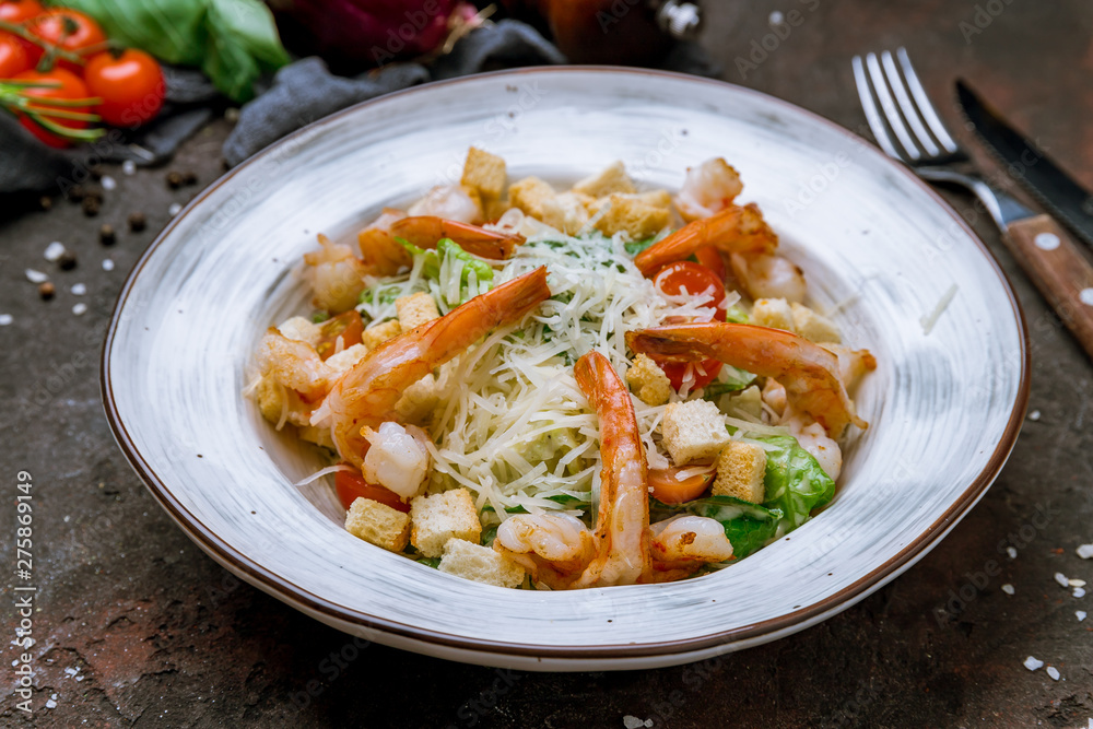 salad caesar with shrimps on dark concrete rustic background salad caesar with shrimps on dark concrete rustic background