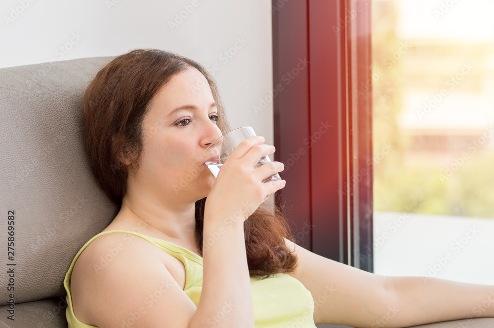 Woman drinking water at home Woman drinking water at home