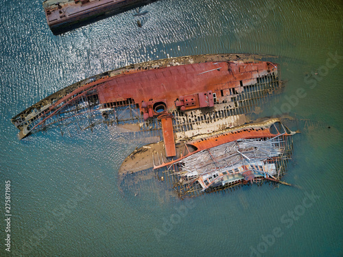 Aerial drone image of Sunken and rotting Wood ships and rotting hulls and rusting  Iron ships with some leaking chemicals and oil into the local creek in Staten Island New York photo