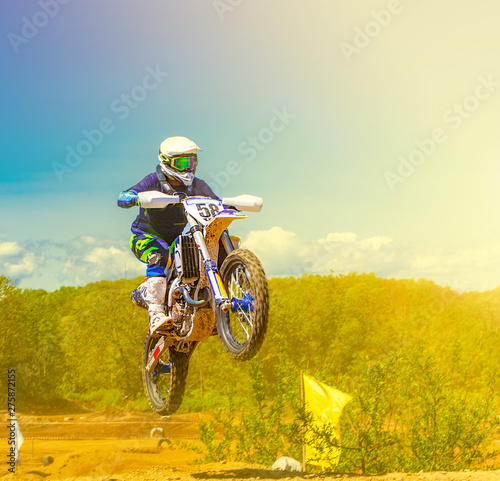 The motocross riders practice tricks on their dirt bikes on a sunny day in Kamchatka