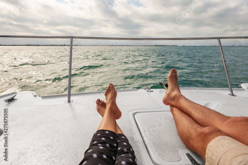 Yacht boat lifestyle couple relaxing on cruise ship in Hawaii holiday . Two tourists feet relax getaway enjoying summer vacation.
