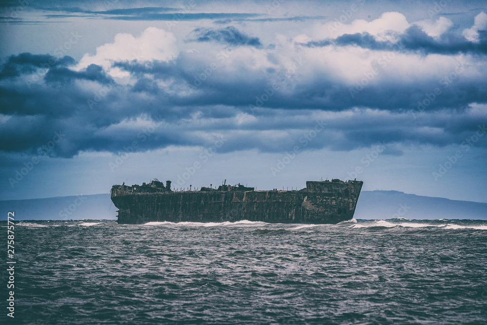 Shipwreck Beach in Lanai island, Hawaii, USA travel. Old ship wreck in the ocean. Shipwreck Beach in Lanai island, Hawaii, USA travel. Old ship wreck in the ocean.