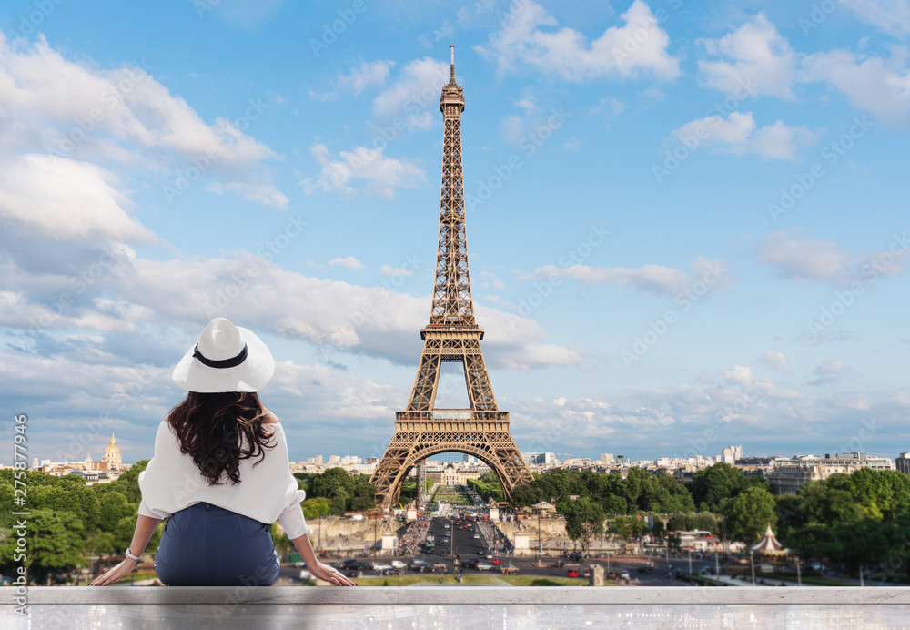 Cercles muraux Femme jeune voyageuse au chapeau blanc regardant la tour  Eiffel, célèbre point de repère et destination de voyage à Paris -  Nikkel-Art.fr