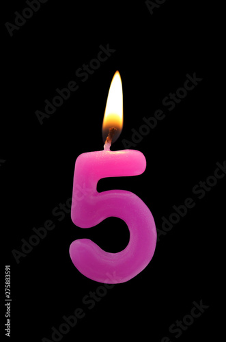 Birthday candle isolated on black background, number 5