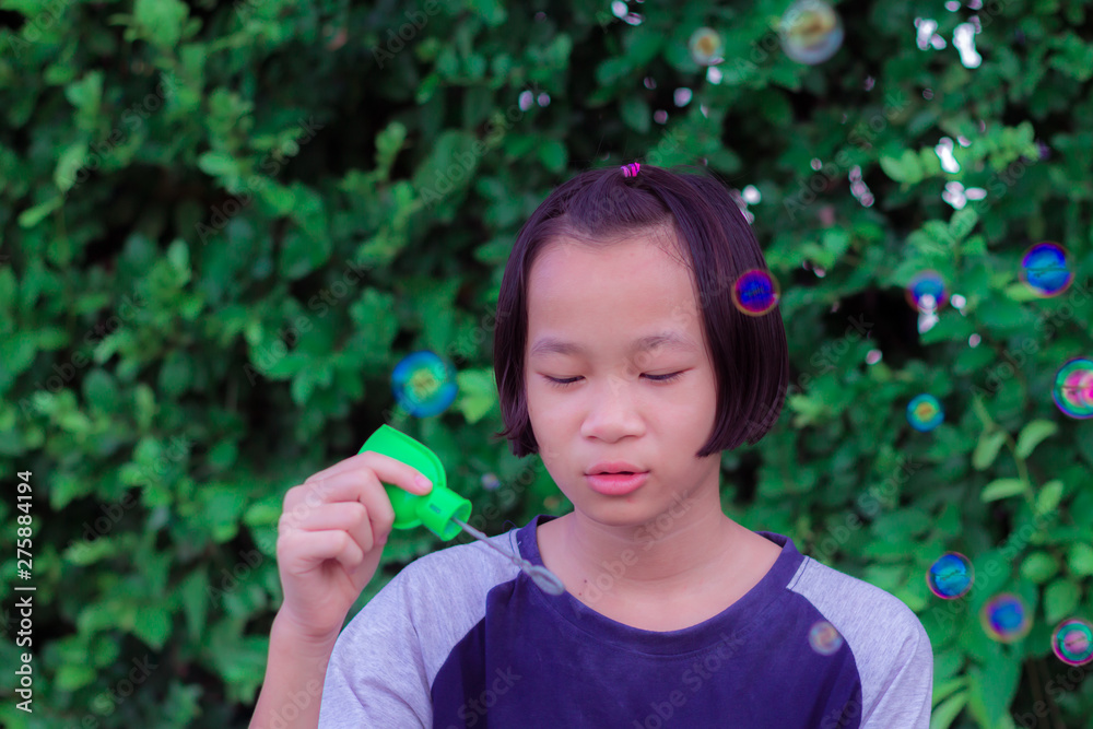 A little girl blowing soap bubbles. child happy play in park A little girl blowing soap bubbles. child happy play in park