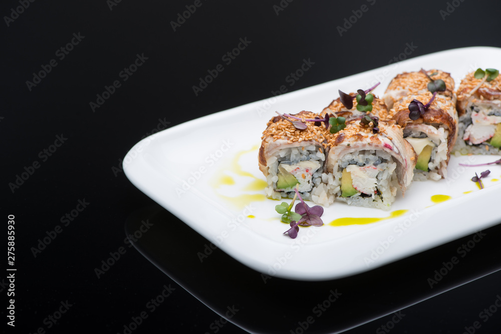 sushi in a plate on a black background with reflection. fish roll