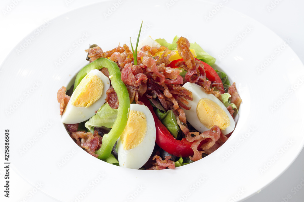 Fresh Caesar Salad with Deep-fried Bacon and Boiled Egg on White Porcelain Round Dish, on White Background with Shadow. Close Up High Angle Side View, Selective Focus at Food. Fresh Caesar Salad with Deep-fried Bacon and Boiled Egg on White Porcelain Round Dish, on White Background with Shadow. Close Up High Angle Side View, Selective Focus at Food.