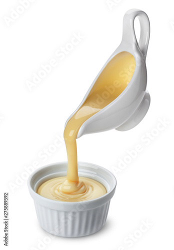 Pouring condensed milk isolated on white background