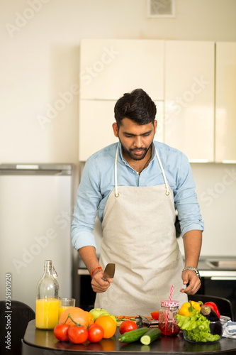 Handsome young man standing in the kitchen at home