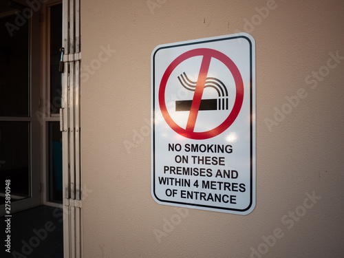 Sign of ' No Smoking on These Premises And Within 4 Metres of Entrance' on wall. Melbourne, VIC Australia. photo