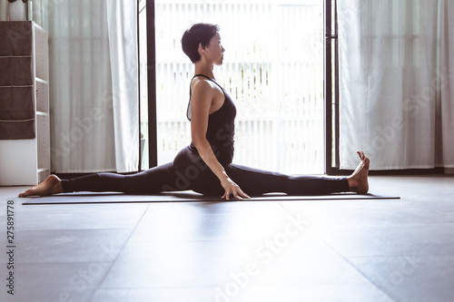 Young woman practicing yoga in gray background.Young people do yoga indoor