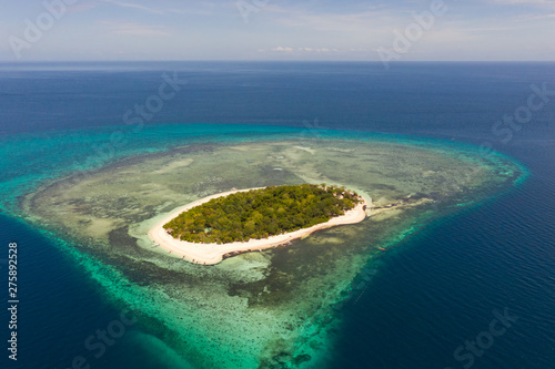 Mantigue Island, Philippines. Atoll with a tropical island. Round islet with a white beach and tropical trees, view from above.