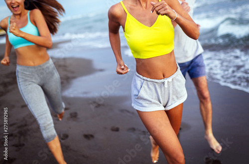 Group of sport people jogging on the beach