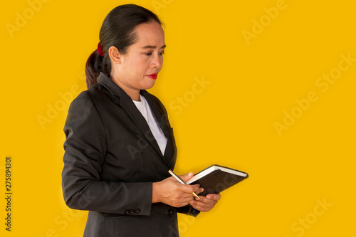 Business woman holding notebook isolated on yellow background.