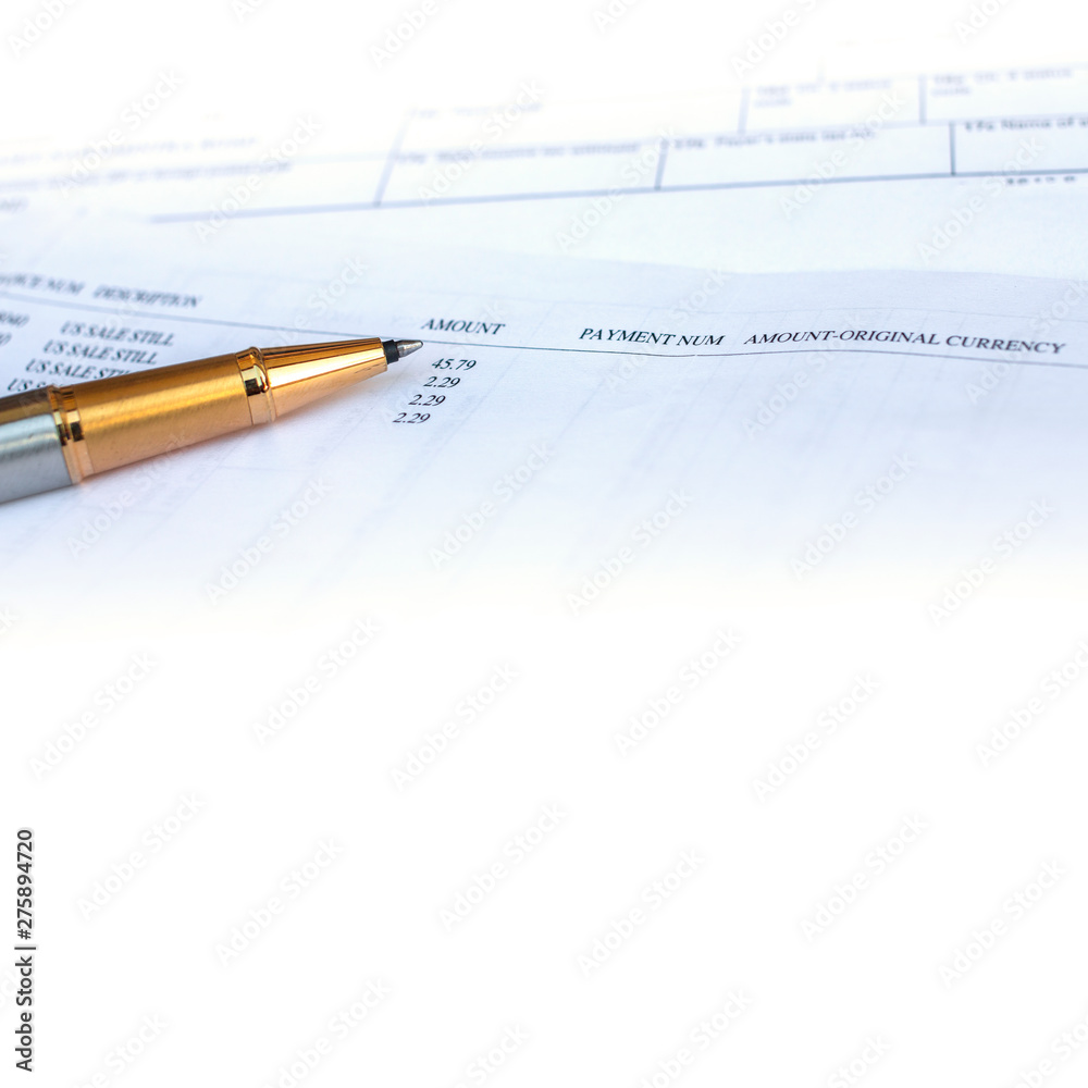 Low angle view of golden pen lying on white sheet of paper in a folder with another set of paperwork Low angle view of golden pen lying on white sheet of paper in a folder with another set of paperwork