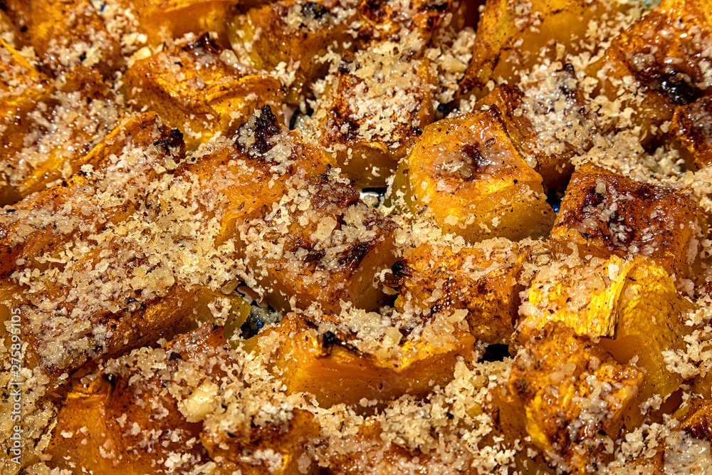 Delicious pieces of roasted pumpkin with crushed walnuts. Close up Delicious pieces of roasted pumpkin with crushed walnuts. Close up