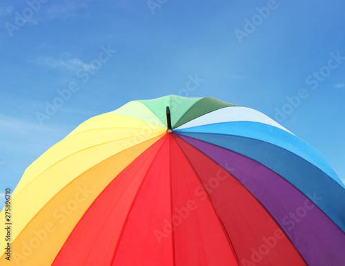 Rainbow umbrella on blue sky background