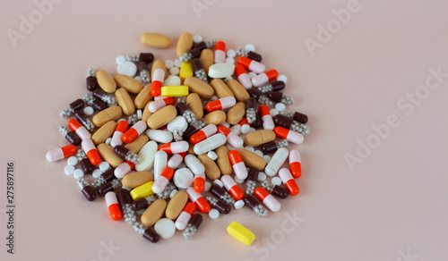 Multicolored different pills on the beige background. Treatment of viruses, sickness, excess weight, depression, insomnia and diseases. Doctor's appointment and prescription drugs