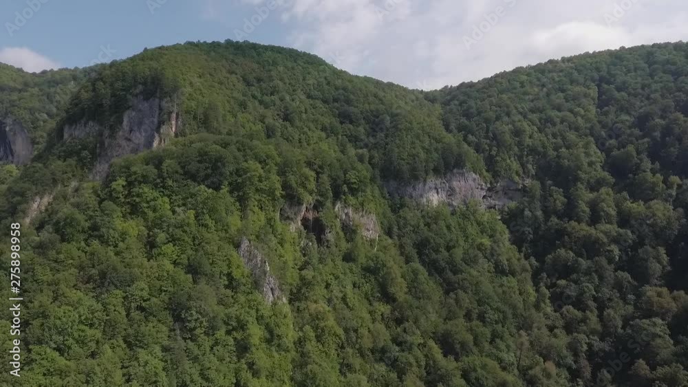 Aerial view of waterfall on a rocky hillside which is covered with forest Aerial view of waterfall on a rocky hillside which is covered with forest