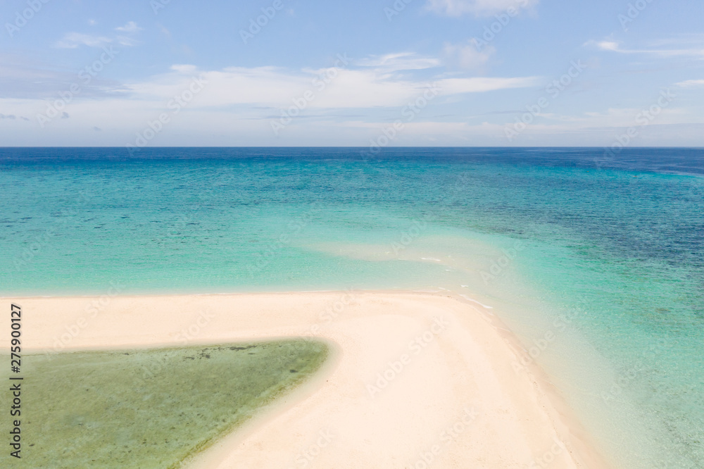 Sand beach island on a coral reef, top view. Atoll with an island of white sand.