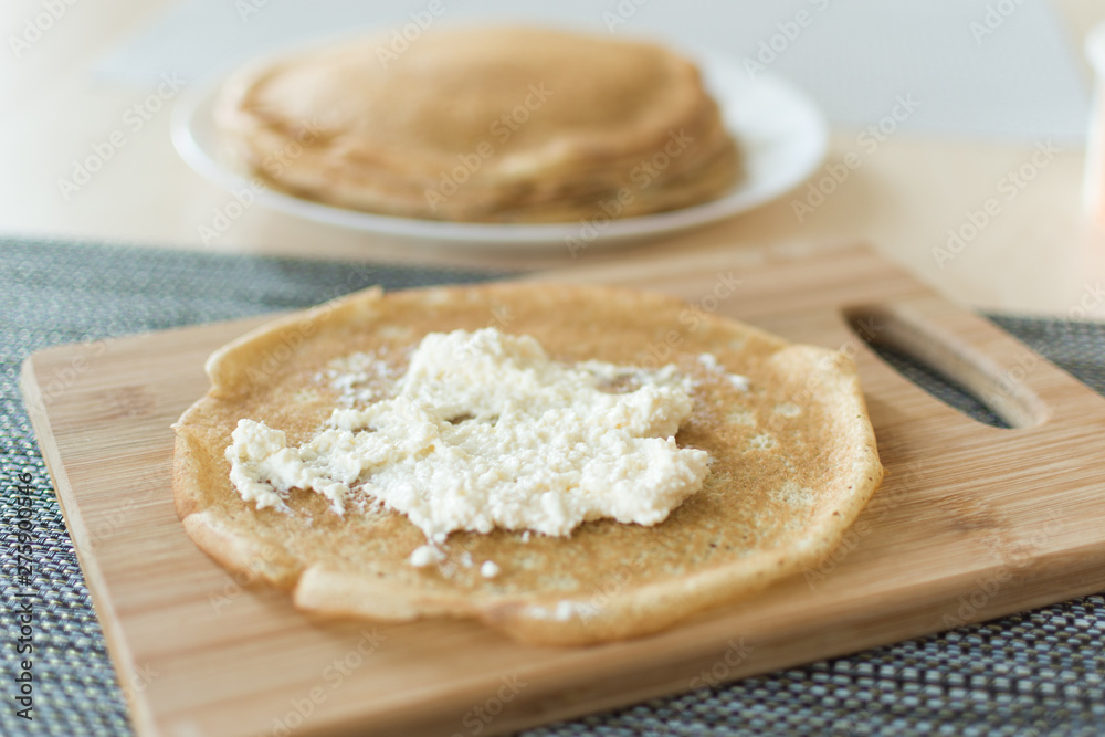 Traditional russian pancakes staffed with cottage cheese. Thin homemade pancakes with crispy crust. Maslenitsa holiday.