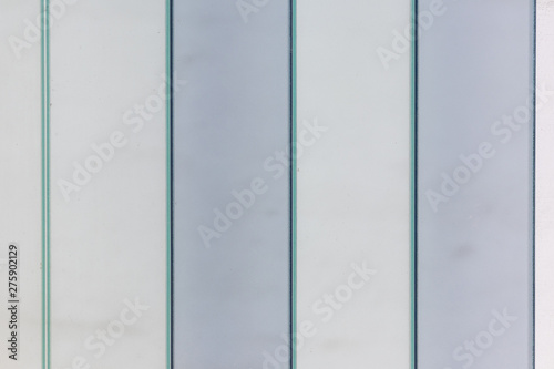 Verschiedenfarbige Glasscheiben einer Fassade mit senkrechten Linien und klaren Formen zeigt ein schönes Muster als Glashintergrund mit klaren Linien, milchigem Glas als undurchsichtigem Sichtschutz photo
