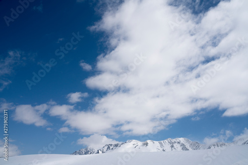 晴れた日の山で撮影した一面の雪景色と青空 © のぞみ 田中