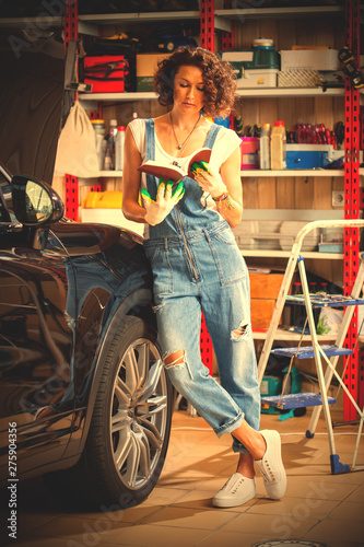 car mechanic, a beautiful woman studying the instructions for repair and adjustment of the car