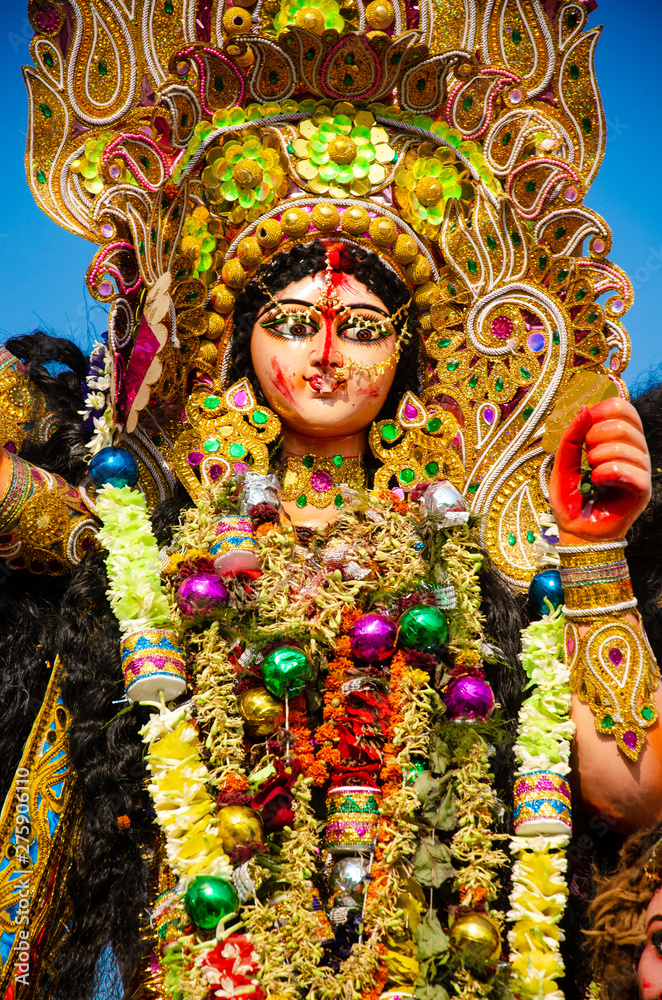 Fototapeta premium Golden and colorful statue of ten handed goddess Durga being worshiped with flower on the occasion of durga puja in Kolkata, India.