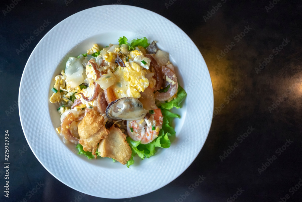 Stir-fried rice noodle with seafood such as prawn, mussel, fried fish, squid. (Kuaitiao khua kai) Thai fried rice noodle top view. Stir-fried rice noodle with seafood such as prawn, mussel, fried fish, squid. (Kuaitiao khua kai) Thai fried rice noodle top view.