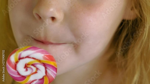 Little girl with a lollipop on a Yellow background. Close up portrait