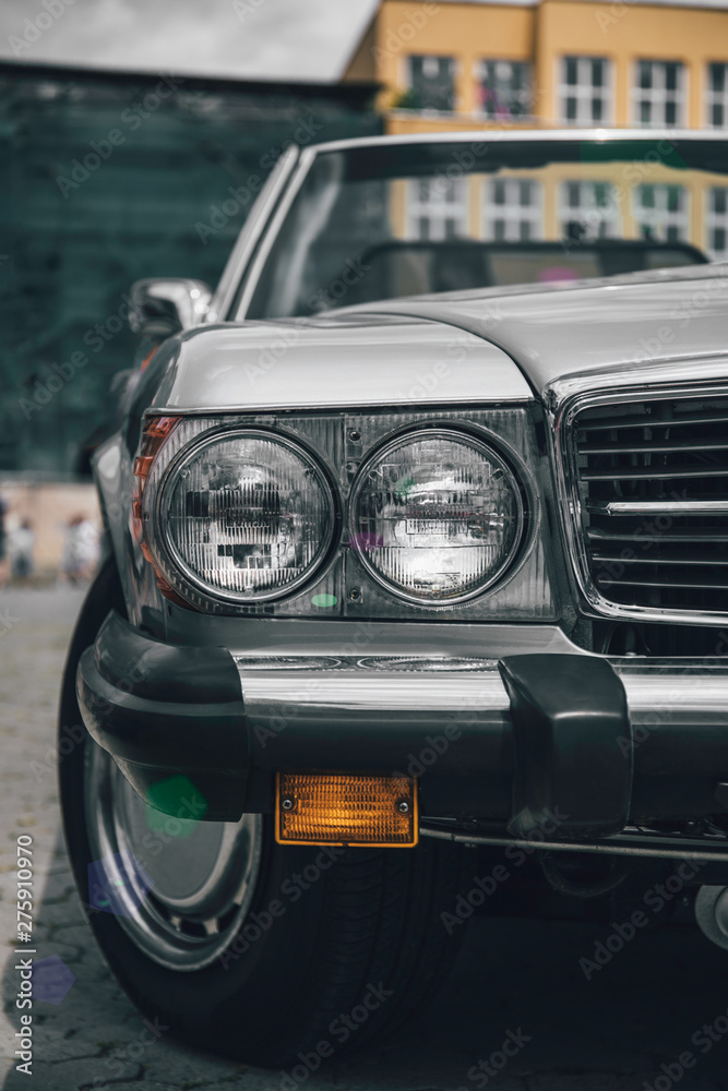 Retro styled image of a front of a grey classic car.