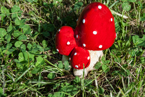 Red toy figures amanita on a Green grass