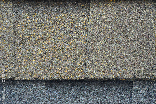 The texture of the rubberized asphalt crumb on the treadmill. The roof of the building is covered with concrete and resin. Background small pieces of brick