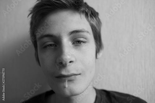 Portrait of a teenager boy flowing saliva from his mouth photo