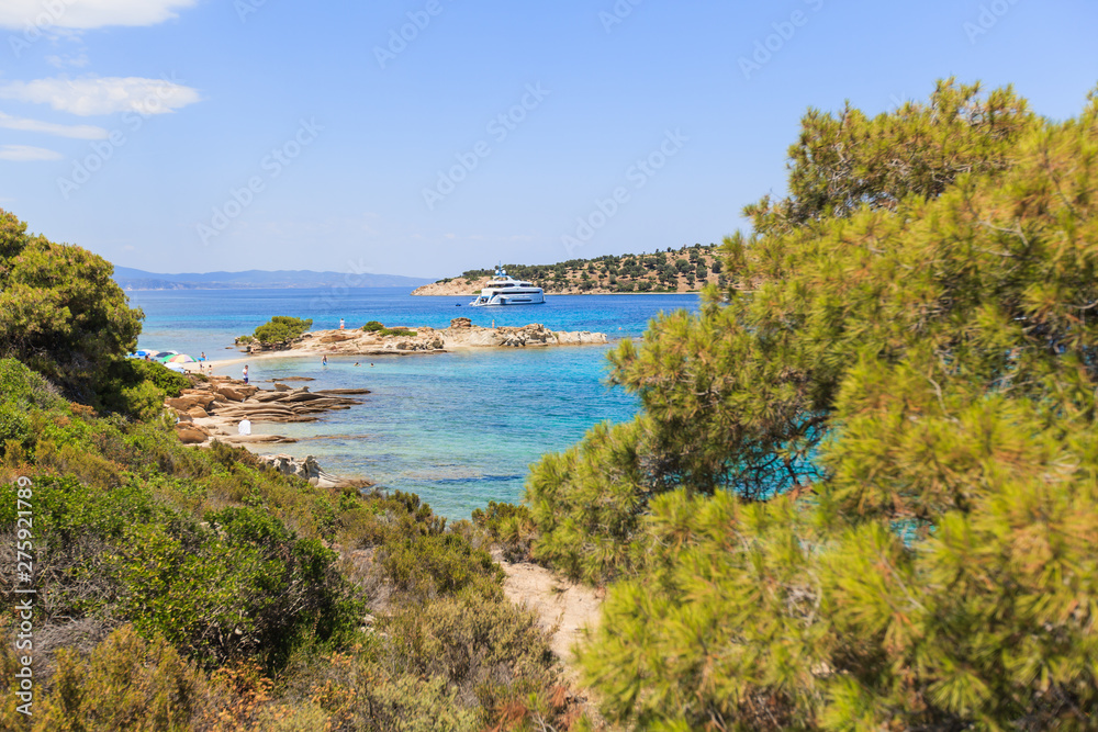 Wonderful summer seascape of turquoise sea water and yacht at coast Sithonia on Halkidiki Greece