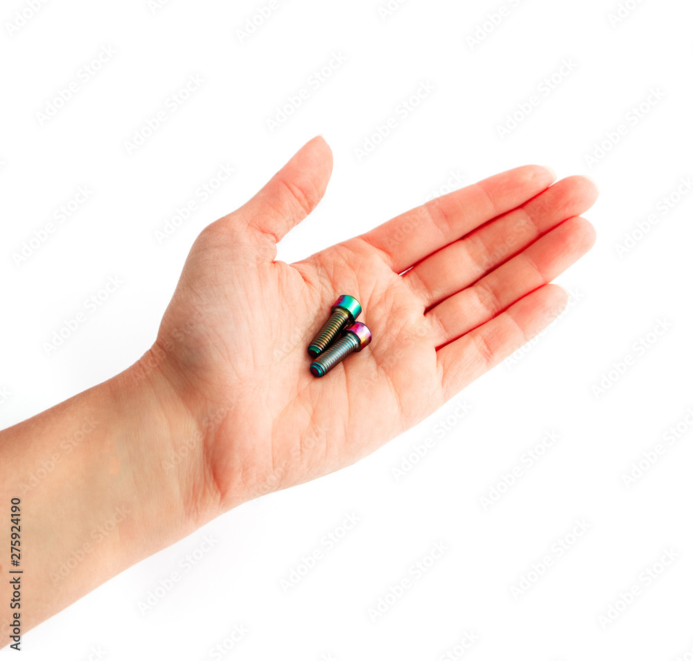 A hand holding a couple of screws. Arm showing bolts, professional work concept. A hand holding a couple of screws. Arm showing bolts, professional work concept.