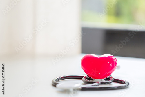 Health care life insurance concept, Simply minimal design with medicine equipment stethoscope or phonendoscope and red heart isolated on trendy pastel blue background. Instrument device for doctor. © doidam10