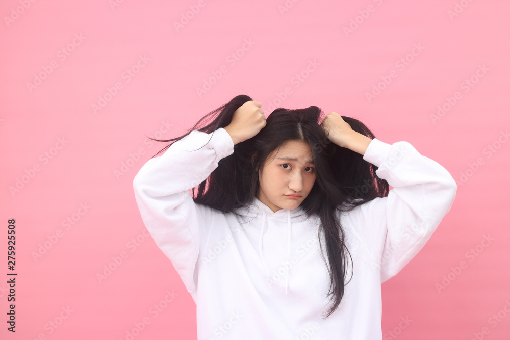 Isolated shot of pretty Beautiful Asian models over pink background for advertising concept , wears casual outfit, being entertained by friend during party Isolated shot of pretty Beautiful Asian models over pink background for advertising concept , wears casual outfit, being entertained by friend during party