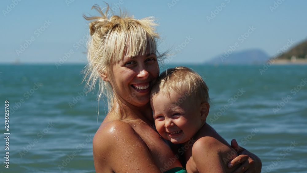 Mother and her little son posing in the water. Mother and her little son posing in the water.