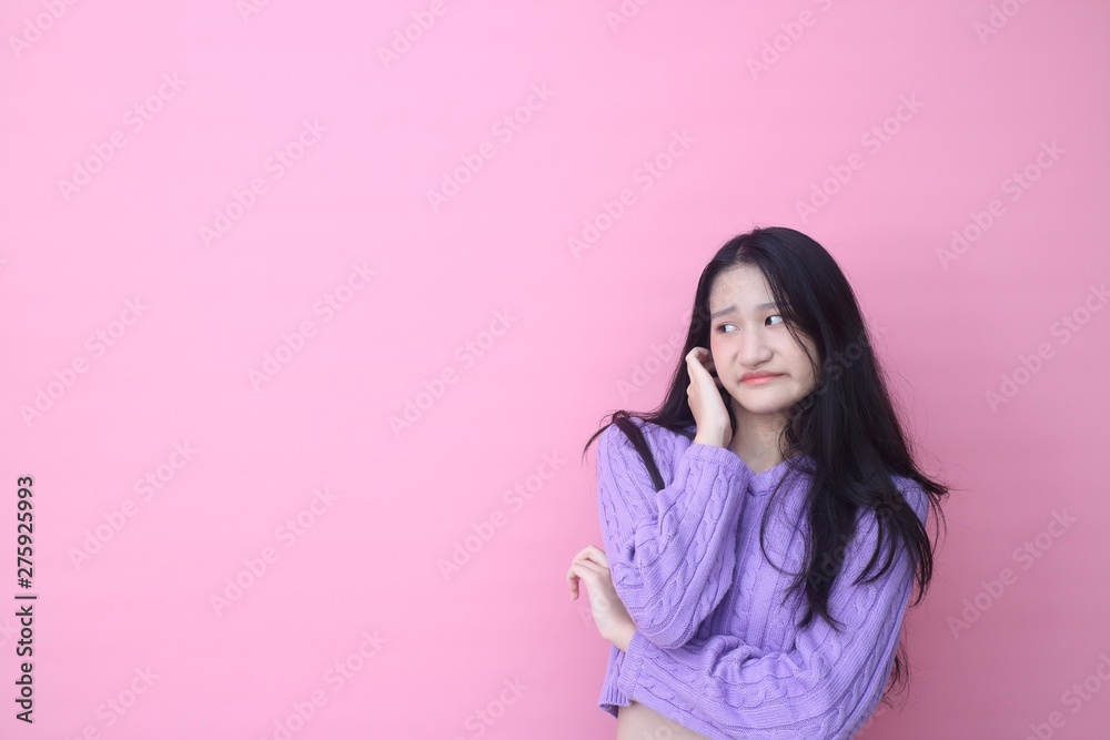Isolated shot of pretty Beautiful Asian models over pink background for advertising concept , wears casual outfit, being entertained by friend during party Isolated shot of pretty Beautiful Asian models over pink background for advertising concept , wears casual outfit, being entertained by friend during party