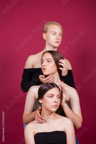 Four beautiful young girls on plum background in studio photo