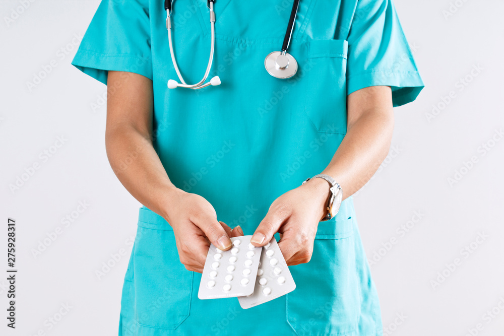 Woman medical doctor hands holding the pills on gray background. Woman medical doctor hands holding the pills on gray background.