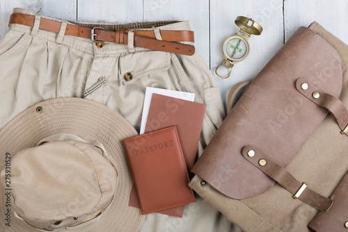 Prepare for journey in safari style, hiking and backpacker - accessories and travel items, packing clothes in backpack: backpack, passport, tickets, hat
