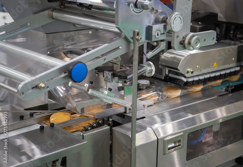 Bread, toast, bun plastic flow wrapping machine on bakery production line. Food industry