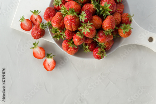 ripe fresh strawberries on a plate on a light background. Healthy, tasty, organic food. Vitamin and fruit concept. The view from the top. Copy space.