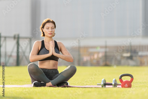 Fotografija Beautiful caucasian brunette fitness model sits in a lotus cross legged position
